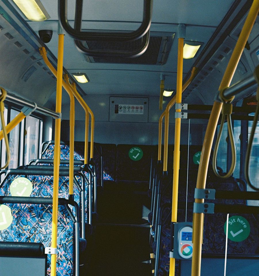 A public transportation bus featuring eye-catching yellow and green seating, perfect for city travel. A public transportation bus featuring eye-catching yellow and green seating, perfect for city travel.