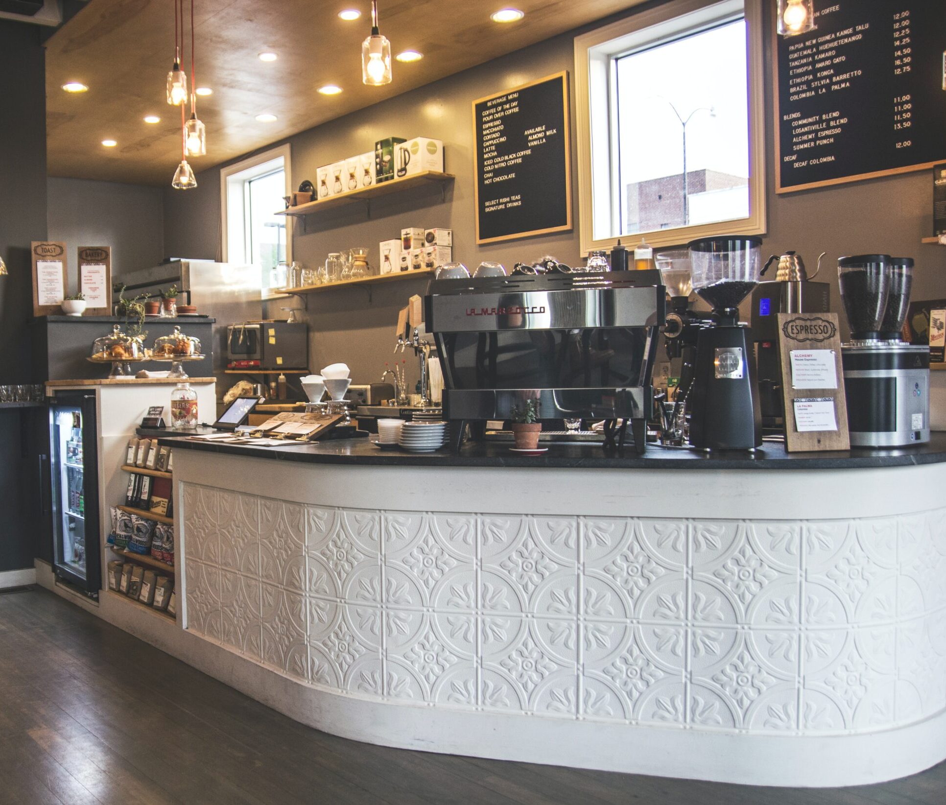 Inside a coffee shop, a polished counter and a stylish bar area are showcased, inviting patrons to enjoy their favorite beverages. Inside a coffee shop, a polished counter and a stylish bar area are showcased, inviting patrons to enjoy their favorite beverages.