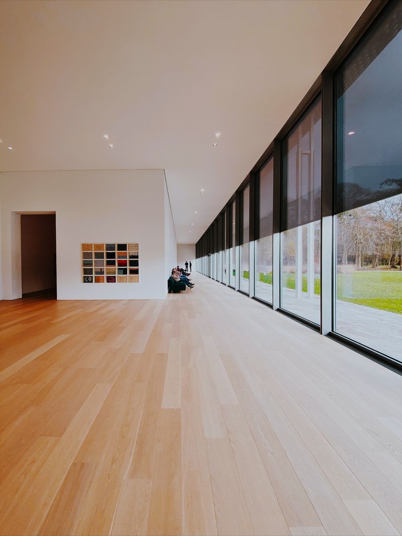 Spacious room with ample natural light, showcasing wooden floors and expansive windows. Spacious room with ample natural light, showcasing wooden floors and expansive windows.