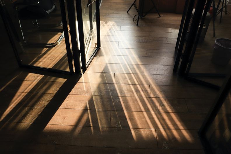 Bright sunlight filtering through transparent glass doors into a well-lit room. Bright sunlight filtering through transparent glass doors into a well-lit room.
