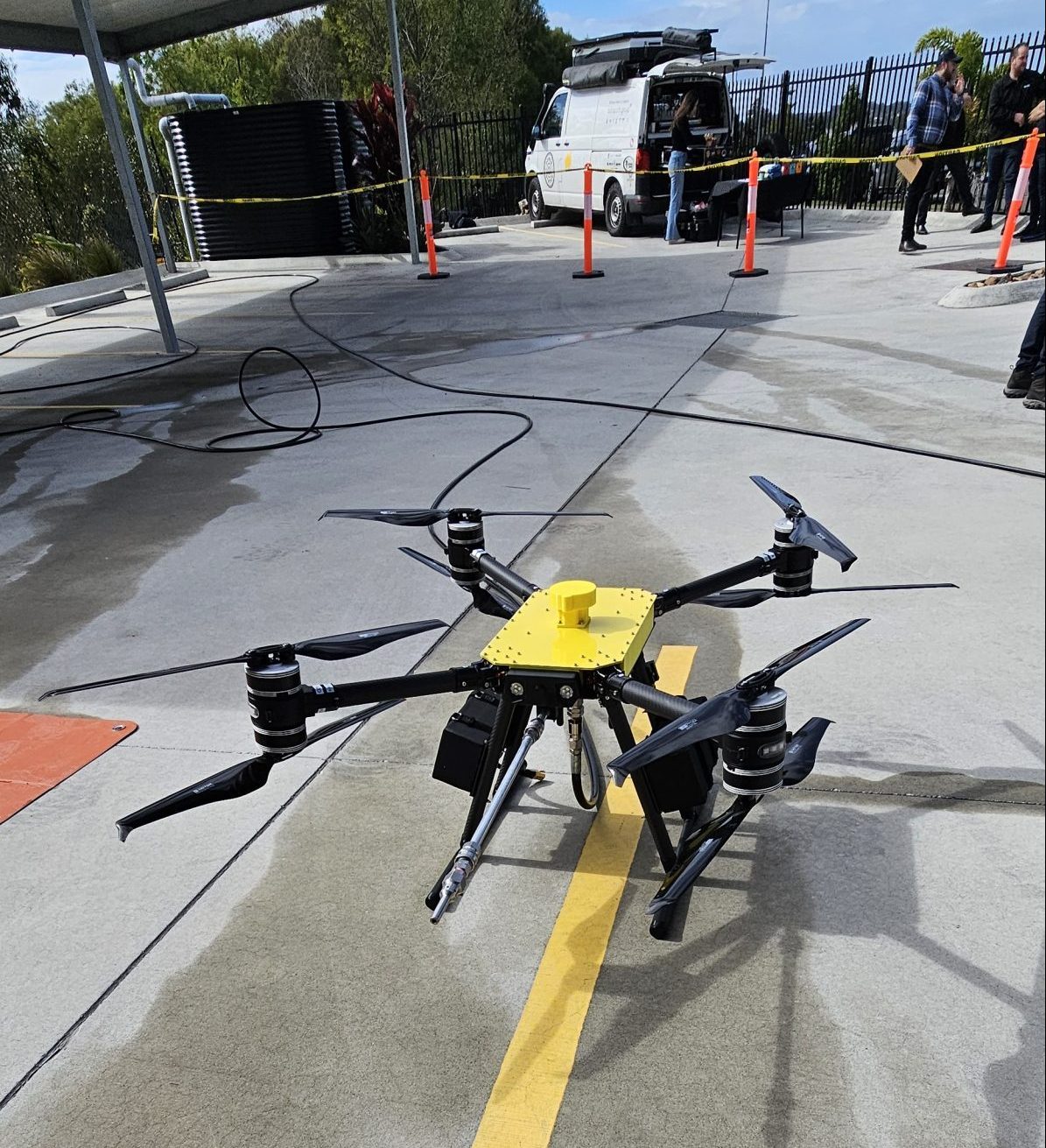Revolutionising Exterior Cleaning with Drone Technology: Safe & Efficient Building Maintenance Drone performing high-pressure exterior cleaning on a commercial building roof, showcasing advanced cleaning technology.